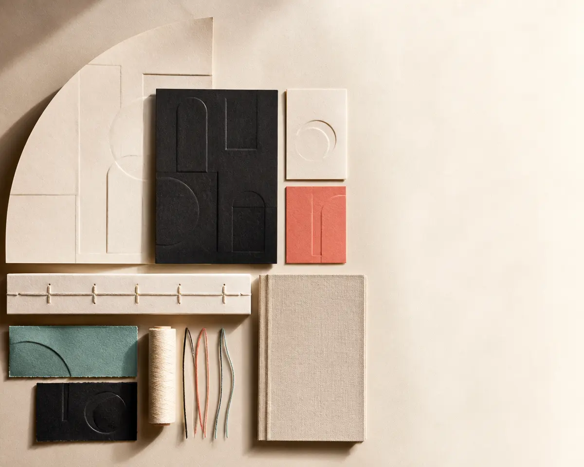 Cut paper, binding thread, book cloth, and embossed abstract forms arranged as an edition study