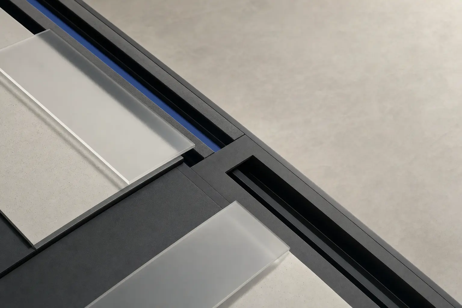 Close crop of pale and charcoal planes meeting around a narrow cobalt channel.